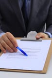 Bedrijfsmens die een contract ondertekenen, die op het bureau zitten royalty-vrije stock fotografie Bedrijfsmens die een contract ondertekenen, die op het bureau zitten royalty-vrije stock fotografie