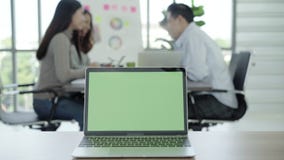 Bedrijfstechnologieconcepten - Digitaal levensstijl werkend bureau Laptop computer met het groene scherm op lijst in bureau Twee Bedrijfstechnologieconcepten - Digitaal levensstijl werkend bureau Laptop computer met het groene scherm op lijst in bureau Twee