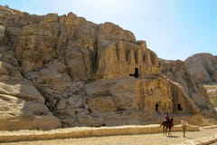Beduine begleitet einen touristischen Reiter auf einem Pferd auf dem Hintergrund von alten Felsen und von Höhlen lizenzfreie stockfotos Beduine begleitet einen touristischen Reiter auf einem Pferd auf dem Hintergrund von alten Felsen und von Höhlen lizenzfreie stockfotos