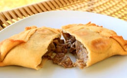 Beef filled Empanada or Empanada de Pino, delicious Chilean baked pasty served on white plate stock photo Beef filled Empanada or Empanada de Pino, delicious Chilean baked pasty served on white plate stock photo