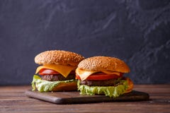 Beeld van twee hamburgers op houten lijst stock foto Beeld van twee hamburgers op houten lijst stock foto