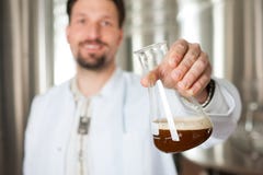 Beer brewer in his brewery examining Royalty Free Stock Photo Beer brewer in his brewery examining Royalty Free Stock Photo