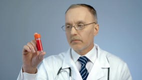 Behandeln Sie das Betrachten der Phiole mit gespendeter Blutprobe nach Analyse, HIV-Bewusstsein lizenzfreies stockfoto Behandeln Sie das Betrachten der Phiole mit gespendeter Blutprobe nach Analyse, HIV-Bewusstsein lizenzfreies stockfoto
