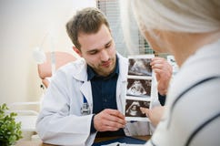 Behandeln Sie das Zeigen des Babyultraschallbildes zur schwangeren Frau Stockfoto Behandeln Sie das Zeigen des Babyultraschallbildes zur schwangeren Frau Stockfoto