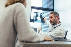 Behandeln Sie das Zeigen des Röntgenstrahls zu seinem Patienten im Ärztlichen Dienst stockbilder Behandeln Sie das Zeigen des Röntgenstrahls zu seinem Patienten im Ärztlichen Dienst stockbilder