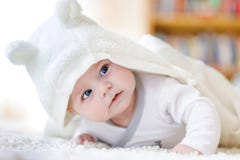 Behandla som ett barn den bärande vita handduken för flickan eller övervintra overal i det vita soliga sovrummet Royaltyfri Foto Behandla som ett barn den bärande vita handduken för flickan eller övervintra overal i det vita soliga sovrummet Royaltyfri Foto