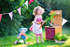 Bei bambini che giocano con la cucina del giocattolo nel giardino Bei bambini che giocano con la cucina del giocattolo nel giardino