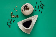 Beignet avec le glaçage blanc et la belle tasse blanche avec du café sur le fond en bon état avec des grains de café, concept de photographie stock Beignet avec le glaçage blanc et la belle tasse blanche avec du café sur le fond en bon état avec des grains de café, concept de photographie stock