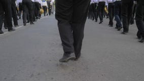 Beine von den jungen Seeleuten, die in der Hand mit Musikinstrumenten auf Parade in der Straße marschieren stock footage Beine von den jungen Seeleuten, die in der Hand mit Musikinstrumenten auf Parade in der Straße marschieren stock footage