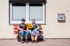 Bejaard die paar van strozitting wordt gemaakt op een houten bank voor een huis royalty-vrije stock afbeeldingen Bejaard die paar van strozitting wordt gemaakt op een houten bank voor een huis royalty-vrije stock afbeeldingen