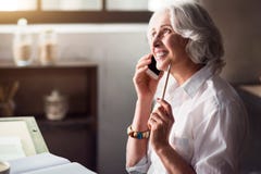 Bejaarde glimlachende vrouw die op de telefoon spreken royalty-vrije stock afbeelding Bejaarde glimlachende vrouw die op de telefoon spreken royalty-vrije stock afbeelding