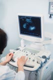 Bekwame sonographer die ultrasone klankmachine met behulp van op het werk Royalty-vrije Stock Afbeeldingen Bekwame sonographer die ultrasone klankmachine met behulp van op het werk Royalty-vrije Stock Afbeeldingen