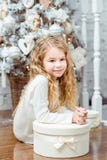 Bella bambina bionda che si siede nell'ambito dello spirito dell'albero di Natale Fotografia Stock Libera da Diritti Bella bambina bionda che si siede nell'ambito dello spirito dell'albero di Natale Fotografia Stock Libera da Diritti
