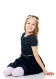 Bella bambina che posa seduta sul pavimento fotografia stock Bella bambina che posa seduta sul pavimento fotografia stock