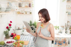 Bella donna asiatica felice che prepara alimento sano nel kitche fotografia stock libera da diritti Bella donna asiatica felice che prepara alimento sano nel kitche fotografia stock libera da diritti
