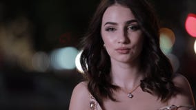 Bella donna attraente che esamina macchina fotografica nella città di notte, movimento lento archivi video Bella donna attraente che esamina macchina fotografica nella città di notte, movimento lento archivi video