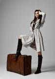 Bella donna castana dei pantaloni a vita bassa in rivestimento grigio di autunno con capelli ventosi che si siedono vicino alla r immagini stock Bella donna castana dei pantaloni a vita bassa in rivestimento grigio di autunno con capelli ventosi che si siedono vicino alla r immagini stock