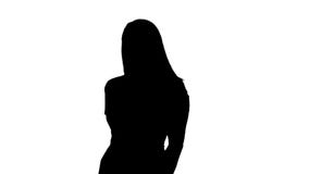 Bella donna della siluetta in vestito rosa che sorride alla macchina fotografica che è timida, immagini stock libere da diritti Bella donna della siluetta in vestito rosa che sorride alla macchina fotografica che è timida, immagini stock libere da diritti