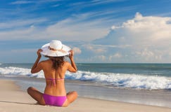 Bella donna di retrovisione alla spiaggia in cappello e bikini fotografia stock Bella donna di retrovisione alla spiaggia in cappello e bikini fotografia stock