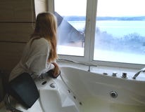 Bella donna in una vasca calda Jacuzzi nell'hotel, vista panoramica dalla finestra nel bagno fotografie stock libere da diritti Bella donna in una vasca calda Jacuzzi nell'hotel, vista panoramica dalla finestra nel bagno fotografie stock libere da diritti
