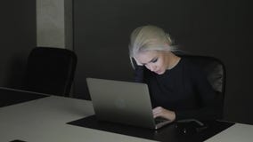 Bella giovane donna bionda che lavora alla notte nell'ufficio, nella crisi video d archivio Bella giovane donna bionda che lavora alla notte nell'ufficio, nella crisi video d archivio
