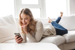Bella giovane donna bionda che si rilassa su uno strato fotografie stock Bella giovane donna bionda che si rilassa su uno strato fotografie stock