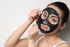 Bella giovane donna che rimuove maschera nera dal suo fronte fotografia stock libera da diritti Bella giovane donna che rimuove maschera nera dal suo fronte fotografia stock libera da diritti