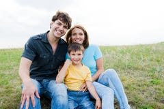 Bella giovane famiglia felice che propone all'aperto fotografia stock libera da diritti Bella giovane famiglia felice che propone all'aperto fotografia stock libera da diritti