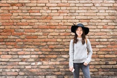 Bella ragazza asiatica in vestito alla moda, stante davanti al fondo rosso del muro di mattoni con lo spazio della copia immagine stock Bella ragazza asiatica in vestito alla moda, stante davanti al fondo rosso del muro di mattoni con lo spazio della copia immagine stock