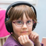 Bella ragazza che ascolta la musica con la cuffia avricolare immagini stock Bella ragazza che ascolta la musica con la cuffia avricolare immagini stock