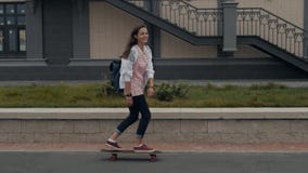 Bella ragazza con il longboard di guida dello zaino nello studente soleggiato di skateboarding del pattinatore del pattino del te video d archivio Bella ragazza con il longboard di guida dello zaino nello studente soleggiato di skateboarding del pattinatore del pattino del te video d archivio