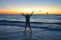 Bella ragazza felice che salta sull'oceano blu alla spiaggia di Clearwater immagine stock libera da diritti Bella ragazza felice che salta sull'oceano blu alla spiaggia di Clearwater immagine stock libera da diritti