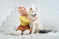 Bella ragazza felice e suo grande il cane bianco che si siedono con il piacere nelle armi Una bella giovane donna ed il suo anima fotografia stock Bella ragazza felice e suo grande il cane bianco che si siedono con il piacere nelle armi Una bella giovane donna ed il suo anima fotografia stock