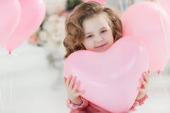 Bella ragazza prescolare in uno studio bianco con i palloni in forma di cuore rosa immagini stock Bella ragazza prescolare in uno studio bianco con i palloni in forma di cuore rosa immagini stock