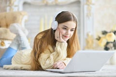 Bella ragazza teenager che si trova sul pavimento e che per mezzo del computer portatile Immagine Stock Bella ragazza teenager che si trova sul pavimento e che per mezzo del computer portatile Immagine Stock