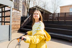 Bella ragazza teenager in un paesaggio urbano con un motorino fotografia stock Bella ragazza teenager in un paesaggio urbano con un motorino fotografia stock