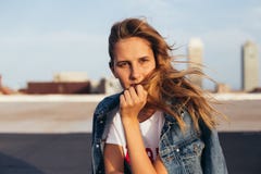 Belle blonde dans la veste de denim avec la planche à roulettes image libre de droits Belle blonde dans la veste de denim avec la planche à roulettes image libre de droits