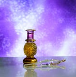 Belle bouteille cosmétique en verre de parfum sur un fond fascinant lilas image stock Belle bouteille cosmétique en verre de parfum sur un fond fascinant lilas image stock