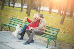 Belle coppie della famiglia con il cane maltese sveglio bianco che spende tempo nel parco di autunno fotografia stock Belle coppie della famiglia con il cane maltese sveglio bianco che spende tempo nel parco di autunno fotografia stock
