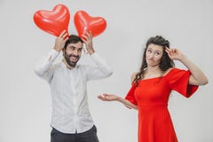 Belle coppie romantiche isolate su fondo bianco Un giovane attraente tiene i palloni sopra la sua testa, la sua fotografie stock Belle coppie romantiche isolate su fondo bianco Un giovane attraente tiene i palloni sopra la sua testa, la sua fotografie stock