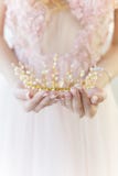 Belle couronne sensible dans le style des beaux-arts à la jeune mariée de-fille de mains image stock Belle couronne sensible dans le style des beaux-arts à la jeune mariée de-fille de mains image stock