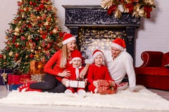 Belle famille de quatre se reposant sur une couverture pelucheuse dans la salle de Noël photo libre de droits Belle famille de quatre se reposant sur une couverture pelucheuse dans la salle de Noël photo libre de droits