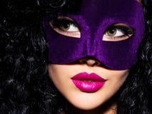 Belle femme avec les poils noirs et masque violet de théâtre sur le fac Photographie stock libre de droits Belle femme avec les poils noirs et masque violet de théâtre sur le fac Photographie stock libre de droits