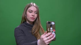 Belle femme d'affaires blonde faisant des selfies utilisant le smartphone d'isolement sur le fond vert de chromakey banque de vidéos Belle femme d'affaires blonde faisant des selfies utilisant le smartphone d'isolement sur le fond vert de chromakey banque de vidéos