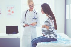 Belle femme enceinte de sourire avec le docteur à l'hôpital image stock Belle femme enceinte de sourire avec le docteur à l'hôpital image stock