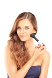 Belle femme tenant une brosse et appliquant le maquillage images libres de droits Belle femme tenant une brosse et appliquant le maquillage images libres de droits