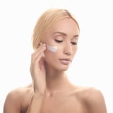 Belle fille avec de la crème cosmétique sur le visage photo stock Belle fille avec de la crème cosmétique sur le visage photo stock