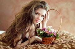 Belle jeune femme avec des fleurs de ressort et le long lyi de cheveux onduleux image libre de droits Belle jeune femme avec des fleurs de ressort et le long lyi de cheveux onduleux image libre de droits