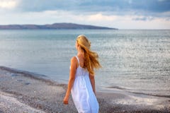 Belle jeune femme dans la robe blanche par la mer au soleil photo libre de droits Belle jeune femme dans la robe blanche par la mer au soleil photo libre de droits