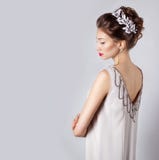 Belle jeune femme de sourire heureuse élégante sexy avec les lèvres rouges, belle coiffure élégante avec les fleurs blanches dans Image stock Belle jeune femme de sourire heureuse élégante sexy avec les lèvres rouges, belle coiffure élégante avec les fleurs blanches dans Image stock